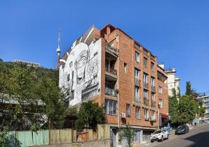 ein Gebäude mit einem Wandbild an der Seite in der Unterkunft Apartment next to Funicular Station in Tbilisi City
