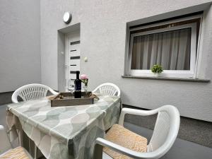a table and chairs on a balcony with a window at Apartments Easy in Dramalj
