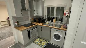 uma cozinha com um lavatório e uma máquina de lavar roupa em Entire One Double Bedroom apartment em Londres