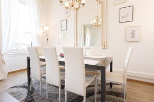 une salle à manger avec une table noire et des chaises blanches dans l'établissement Apartments Center Colmar, à Colmar