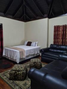 a living room with a bed and a couch at Stunning 3-Bedroom house in Ocho Rios Upton in Ocho Rios