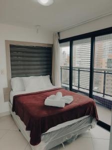 1 dormitorio con 1 cama y 2 toallas blancas en Landscape: Conforto com Varanda e Vista Mar en Fortaleza