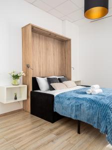 a bedroom with a large bed with a wooden headboard at Al Jerozolimskie 216 APART-WAWA in Warsaw