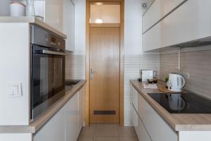 - une cuisine avec des appareils blancs et une porte en bois dans l'établissement Sunny 1BDR with Balcony & Parking, à Zagreb