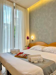 twee bedden in een hotelkamer met handdoeken erop bij Hotel Sara in Milaan