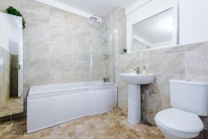 a bathroom with a tub and a toilet and a sink at Manchester City Centre 2 bed apartment in Manchester