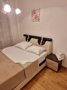 a bedroom with a large bed with a wooden floor at Elegantna oaza apartment in Banja Luka