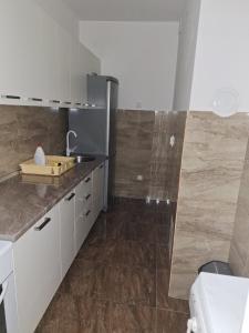a kitchen with white cabinets and a sink at Elegantna oaza apartment in Banja Luka