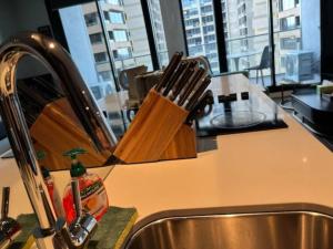 a kitchen counter with a knife block on a sink at City-view High Rise 2BR Apt w/Pool, Sauna Gym, Library near Southern Cross Station Melbourne CBD in Melbourne