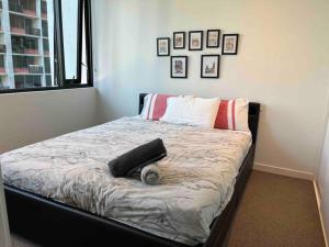 a bedroom with a bed with a cat laying on it at City-view High Rise 2BR Apt w/Pool, Sauna Gym, Library near Southern Cross Station Melbourne CBD in Melbourne