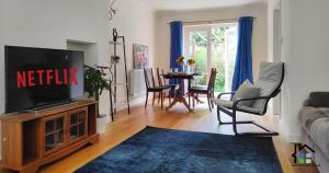 a living room with a television and a table with chairs at Cambridge Stays 3BR House-Garden-Lots of Parking-15 min to City Center- Close to Cambridge Science park in Cambridge