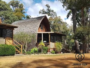 a house with a gambrel roof and a yard at Jarrah Glen Cabins in Nannup