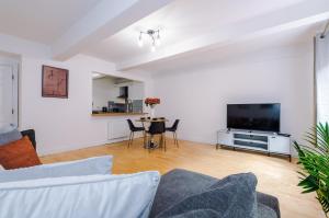 salon z kanapą i telewizorem z płaskim ekranem w obiekcie Manchester City Centre 2 bed apartment w Manchesterze