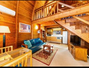 a living room with a blue couch in a wooden cabin at Jarrah Glen Cabins in Nannup