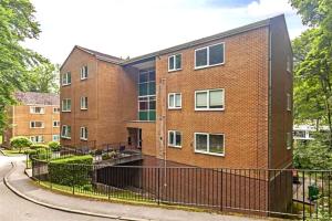 a brick building with a fence in front of it at Countryside Apartment nr. Dore Train station in Sheffield