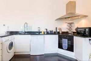 cocina con armarios blancos y fogones en Croft House - By Luxury Apartments, en Cheltenham