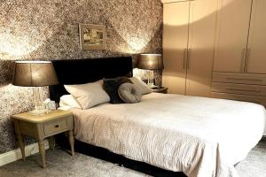 1 dormitorio con 1 cama y mesita de noche con 2 lámparas en Countryside Apartment nr. Dore Train station en Sheffield