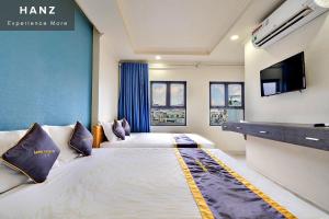 um quarto de hotel com duas camas e uma televisão de ecrã plano em HANZ Minh Thu Hotel Tan Binh em Ho Chi Minh