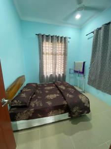 una camera con un letto in una camera blu di Dzanz Homestay a Kampong Pengkalan Maras
