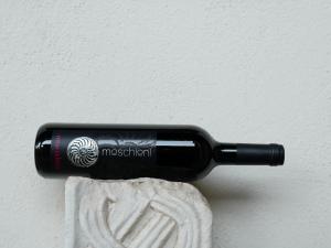 una botella negra de vino sentada en una pared en AZIENDA AGRICOLA MOSCHIONI, en Cividale del Friuli