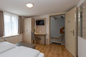 een hotelkamer met een bed, een tafel en een bureau bij Hotel Garni Rössli in St. Gallen