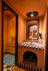 bagno con camino, lavandino e specchio di Riad family a Merzouga