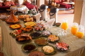 a table with a bunch of food and orange juice at Riad family in Merzouga