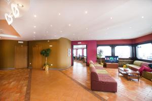 eine Lobby mit Sofas und einem TV in einem Gebäude in der Unterkunft Hotel Dolomiti in Brentonico