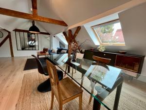 a living room with a glass table and chairs at Le passage des cinq - 5 min du tram 15 min Strasbourg centre in Eckbolsheim
