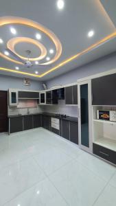 een grote keuken met een witte vloer en een plafond bij Citi Hotel Apartments in Jhelum