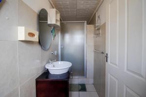 a bathroom with a sink and a shower at Nolapeace B&B in East London