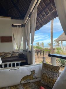 een woonkamer met een bank en uitzicht op het strand bij Villa 23 in Malindi