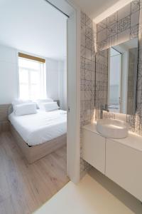 1 dormitorio con cama, lavabo y espejo en A'MAR by Alojamento Ideal, en Póvoa de Varzim