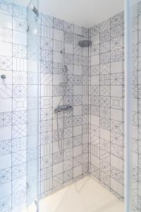 a bathroom with a shower with blue and white tiles at A'MAR by Alojamento Ideal in Póvoa de Varzim