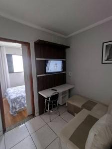 Cette petite chambre comprend un bureau et un lit. dans l'établissement Apartamento ao lado Praça Central, à Poços de Caldas