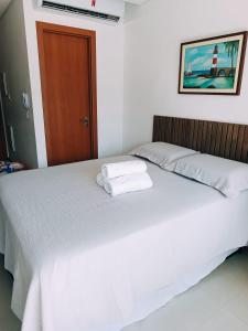 a bedroom with a bed with two towels on it at Barra Pinauna Studio in Salvador