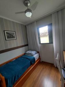 ein kleines Schlafzimmer mit einem Bett und einem Fenster in der Unterkunft Apartamento ao lado Praça Central in Poços de Caldas