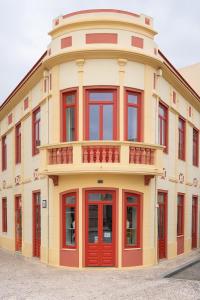 un edificio con puertas rojas y una tapa redonda en A'MAR by Alojamento Ideal, en Póvoa de Varzim