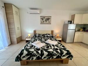 a bedroom with a bed and a refrigerator at Apartments Easy in Dramalj