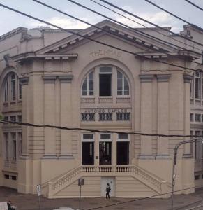 un edificio con una persona parada frente a él en Apartamento ao lado Praça Central en Poços de Caldas