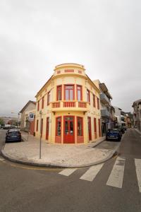 a yellow building on the corner of a street at A'MAR by Alojamento Ideal in Póvoa de Varzim