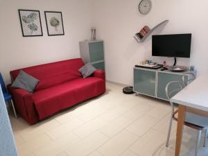 a living room with a red couch and a tv at Pra Livrana in Porlezza