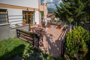 une terrasse avec un banc en bois, une table et des chaises dans l'établissement Opus View, à Sinaia