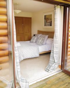a bed in a room with a window at Na Craigean Lodge in White Bridge