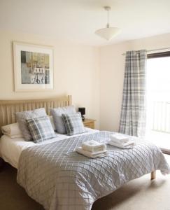 a bedroom with a bed with two towels on it at Na Craigean Lodge in White Bridge