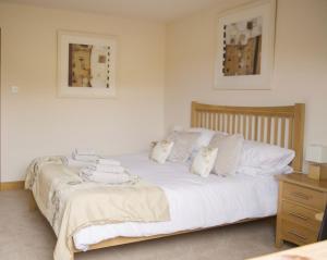 a bedroom with a white bed with towels on it at Na Craigean Lodge in White Bridge