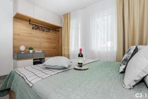 Un dormitorio con una cama con una botella de vino. en KORZO LIPNO C en Lipno nad Vltavou