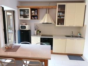 a kitchen with white cabinets and a table with chairs at Pra Livrana in Porlezza