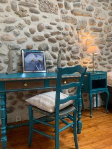 einen blauen Schreibtisch mit einem Stuhl und einem Bild darauf in der Unterkunft Vercors en Vert , chambres d'hôtes de charme in Saint-Romans