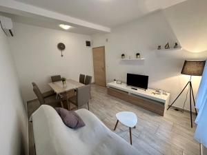 a living room with a couch and a table and a television at Apartments Easy in Dramalj +27 photos